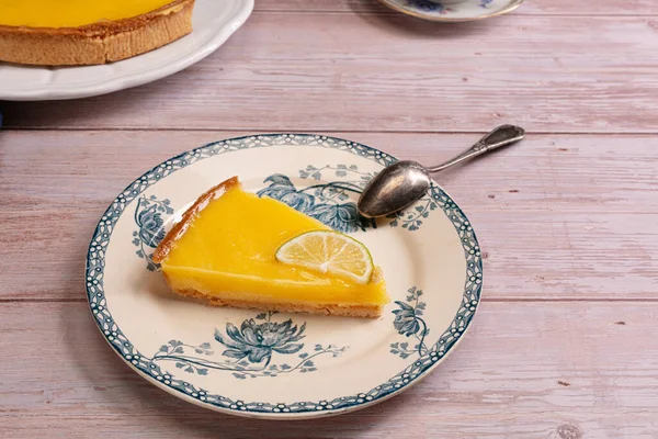Slice of lemon pie on an old plate on a wooden table