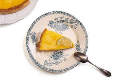 Beyaz arka planda eski bir tabakta limonlu turta.