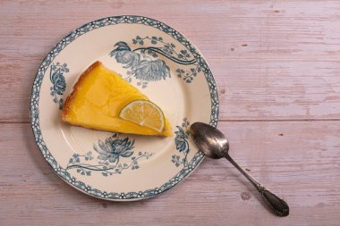 Tahta bir masada eski bir tabakta limonlu turta dilimi