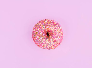 Pembe arka planda küçük şekerli pembe çörek.