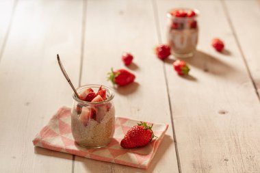 Kırsal arka planda chia ve çilekli puding.