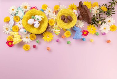 Pembe arka planda Paskalya dekorasyonlu balık ve sütlü çikolata yumurtası.