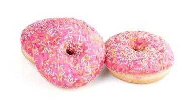 Beyaz arka planda küçük şekerli üç pembe çörek.