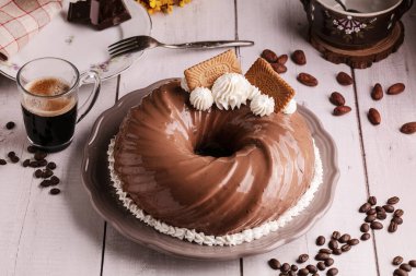 Çikolatalı ve kahveli kek. Tahta bir masanın üzerinde bir fincan kahve.