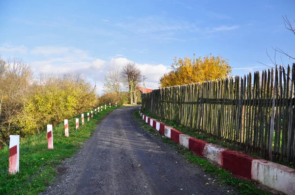 Empty village road among traditional wooden fence — Stock Photo, Image