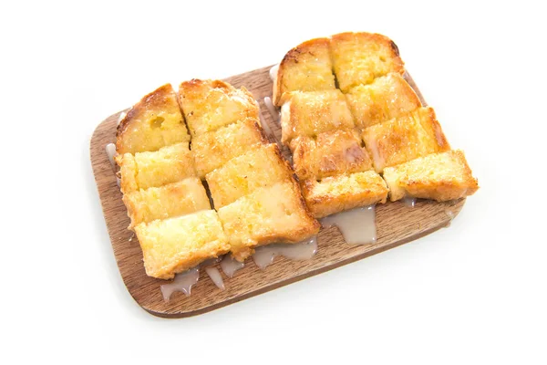 Pane tostato e latte condensato su piastra di legno — Foto Stock