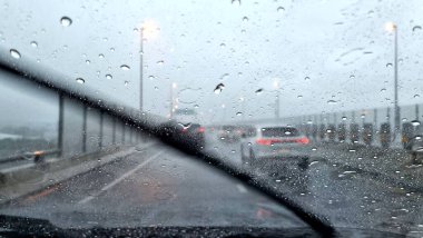Otobanda yağmurlu bir günde ön camda çalışan silecekler..