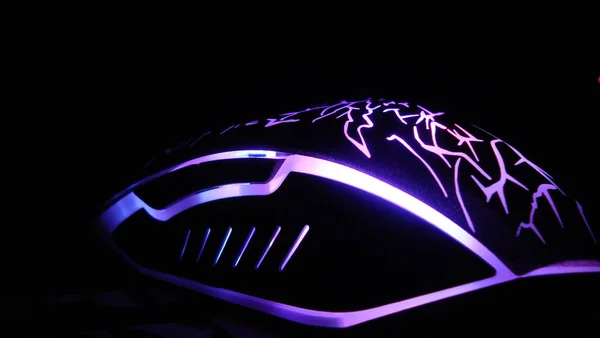 game mouse with bright illumination on a black background of the table