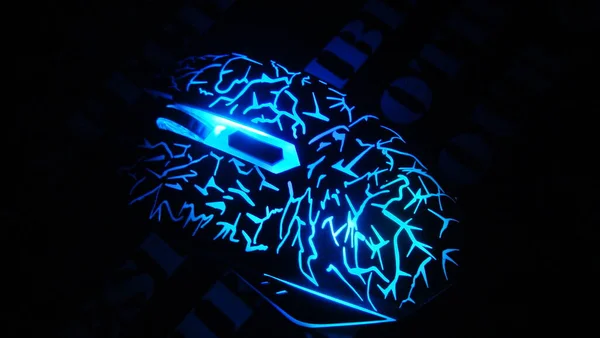 Masanın siyah zemininde parlak ışıklandırmaya sahip oyun faresi