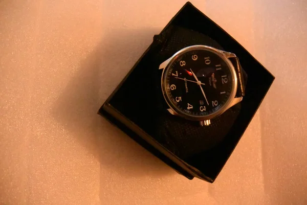 Neue mechanische Uhr auf dem Tisch mit einer warmen Lampenfarbe in einer Box. — Stockfoto