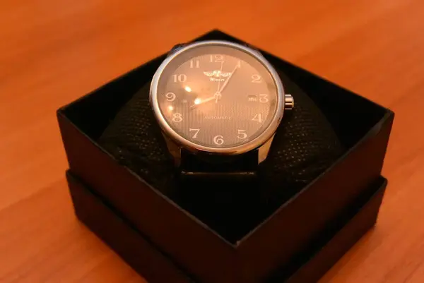 Νέο μηχανικό ρολόι στο τραπέζι με ένα ζεστό χρώμα λαμπτήρα σε ένα κουτί. — Φωτογραφία Αρχείου