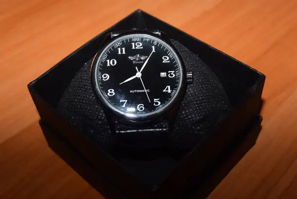 Nuevo reloj mecánico en la mesa con una lámpara de color cálido en una caja. — Foto de Stock