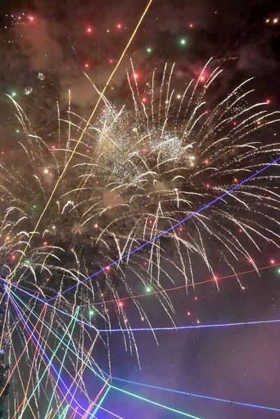 Karanlık bir gökyüzünün aydınlatması. Neon havai fişekler ve Noel ağacı.