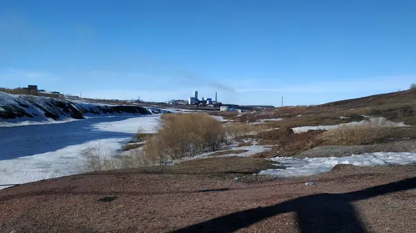 Der Frühling kommt in der nordrussischen Landschaft am Fluss und das alte Dorf am Hang schmilzt der Schnee — Stockfoto