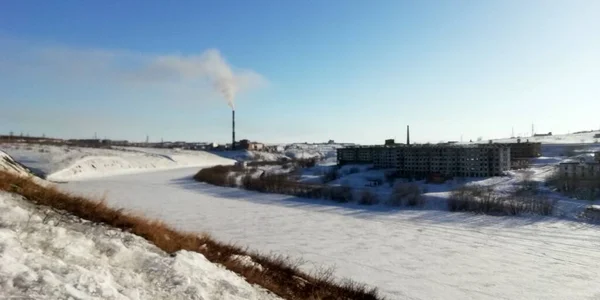 Neve paisagens brancas uma encosta com vista para o rio e uma aldeia abandonada onde as pessoas costumavam viver no norte da Rússia — Fotografia de Stock