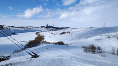 Kar beyazı manzarası nehir manzaralı bir yamaç ve eskiden Rusya 'nın kuzeyinde insanların yaşadığı terk edilmiş bir köy.