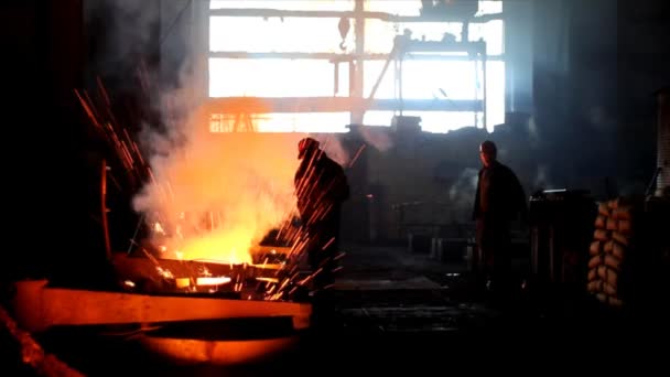 Harte Arbeit in einer Gießerei, wo Eisen geschmolzen wird — Stockvideo