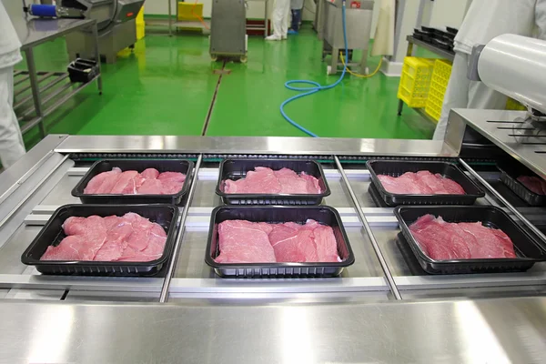 Упаковка шматочків м'яса в коробках на конвеєрному поясі — стокове фото