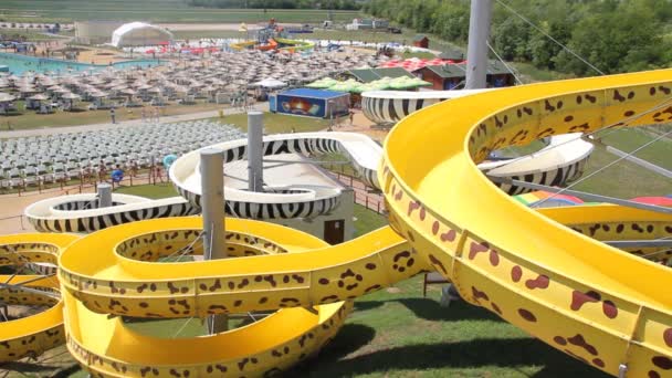 Menschen entspannen sich im Park mit Wasserfahrgeschäften — Stockvideo