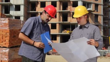 iki adam bina süreci tartışıyor