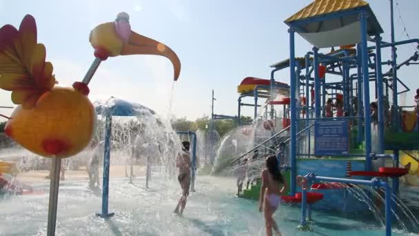 Люди отдыхают в парке с водными аттракционами — стоковое видео
