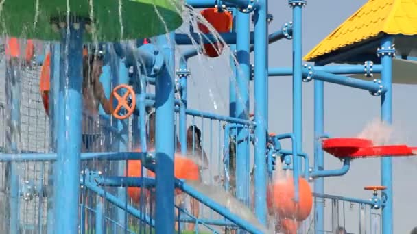 Menschen entspannen sich im Park mit Wasserfahrgeschäften — Stockvideo