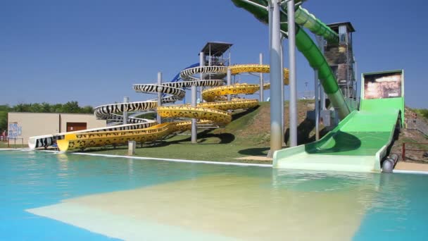 Menschen entspannen sich im Park mit Wasserfahrgeschäften — Stockvideo