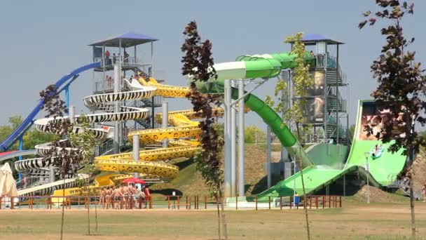 People relaxing in park with water rides — Stock Video