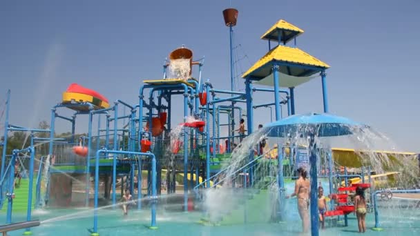 People relaxing in park with water rides — Stock Video