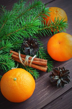 Ahşap bir arka planda kozalaklı dallar ve mandallar. Kış tatiliniz kutlu olsun..