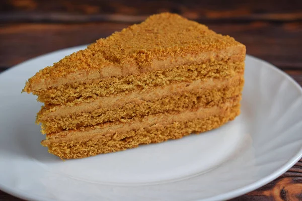 Pedazo Pastel Miel Plato Blanco Sobre Fondo Madera — Foto de Stock