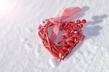 Kırmızı hasır kalp ve karda bir buket dut..