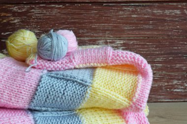 Ahşap bir arka planda iplik ve örgü kumaş.