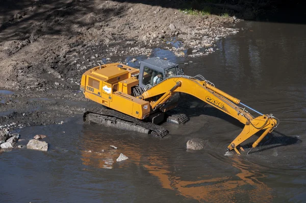 Retroexcavadora trabajando en un río —  Fotos de Stock