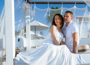 bir baldachin altında oturan kadın ve erkek