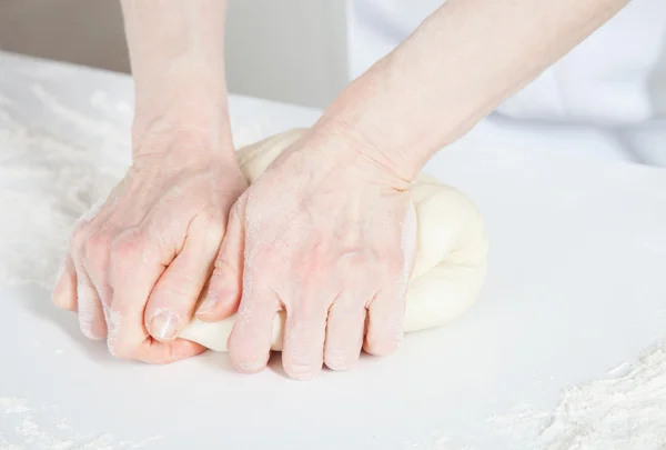 Женские руки месят тесто — стоковое фото