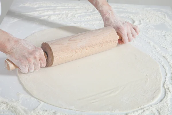 Housewife  flattening a dough with a rolling pin — Stock Photo, Image