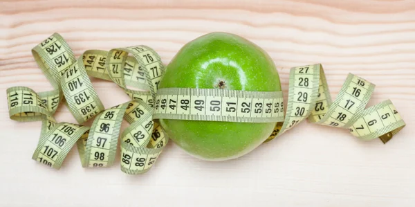 Green apple with tape measure — Stock Photo, Image
