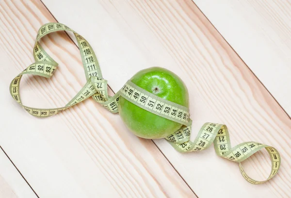 Green apple with tape measure — Stock Photo, Image