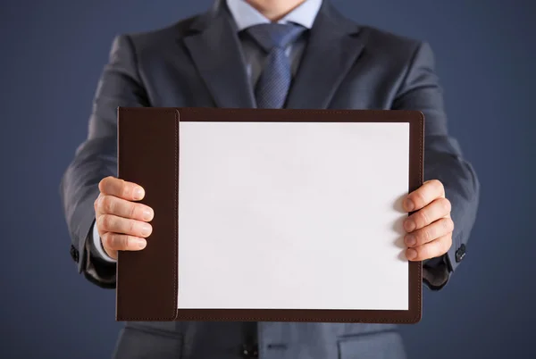 Empresário segurando uma área de transferência com folha de papel vazia — Fotografia de Stock