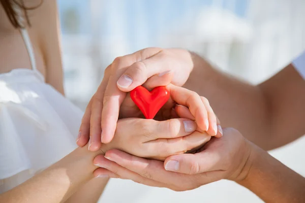 Hands of man and woman holding red heart — Stock Photo, Image