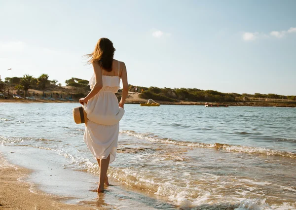 Frau geht am Strand entlang — Stockfoto
