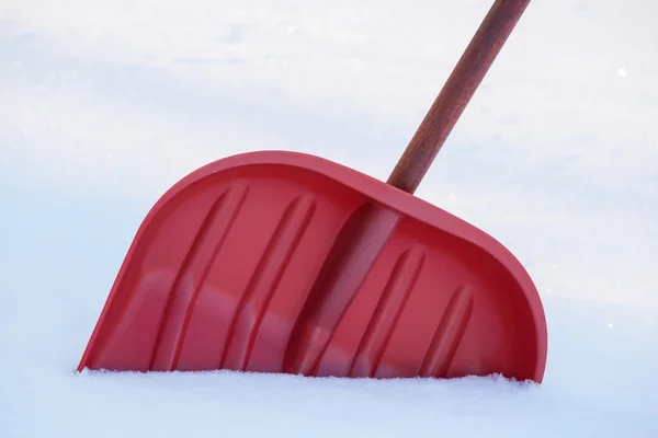Rote Schneeschaufel in der Schneewehe Stockfoto