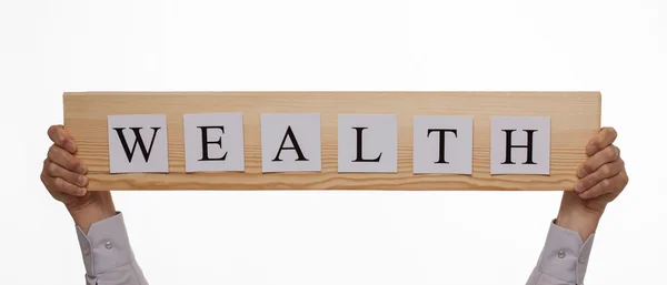 Wooden plate with an inscription "Wealth" — Stock Photo, Image