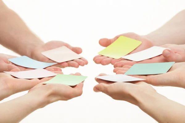 Human hands reaching out colorful paper cards — Stock Photo, Image