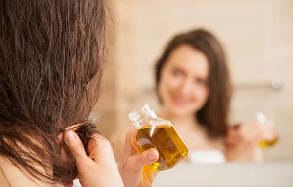 Mulher aplicando máscara de óleo para dicas de cabelo — Fotografia de Stock