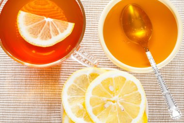 Fincan çay, taze limon ve bal 