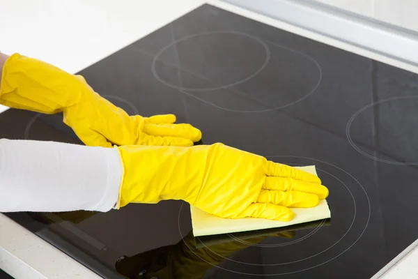 Housewife cleaning an induction plate — Stock Photo, Image