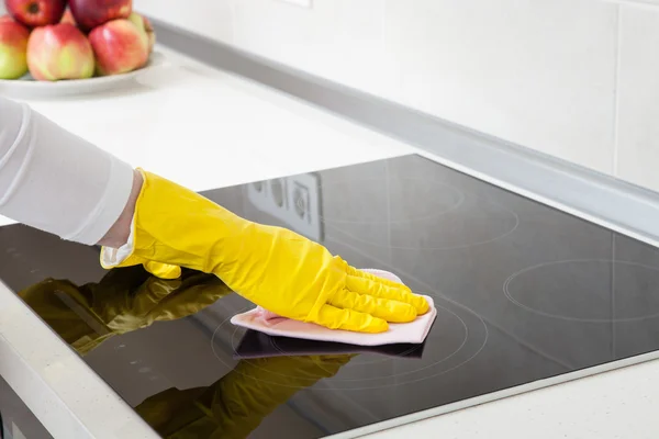 Housewife cleaning an induction plate — Stock Photo, Image