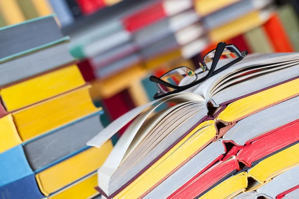 Открытая книга и очки на цветном фоне — стоковое фото